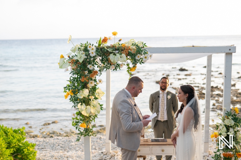 Wedding ceremony at Landhuis San Nicolas in Curacao with ocean backdrop and floral decor
