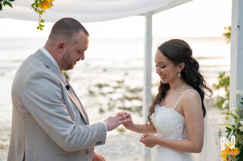 Wedding ceremony at Landhuis San Nicolas in Curacao features a couple exchanging rings during their intimate beachfront vows