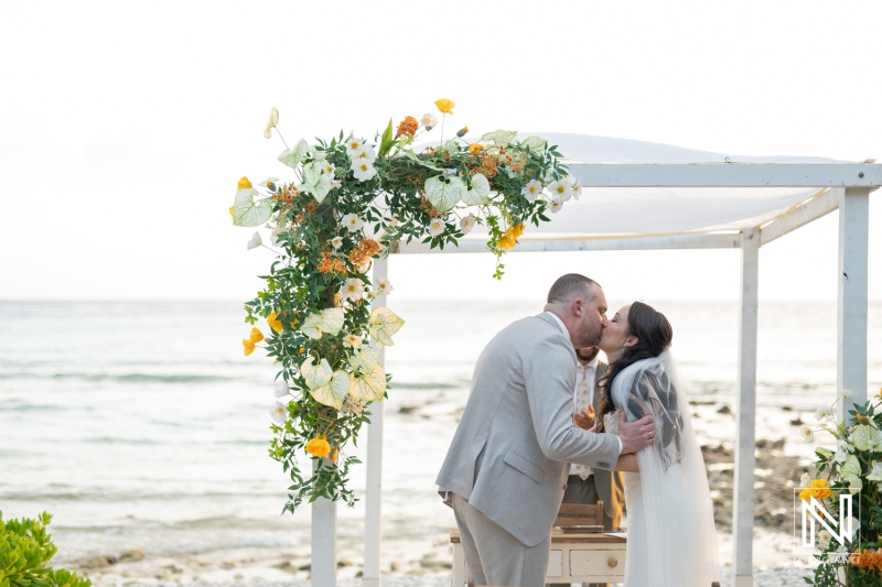 Couple exchanges vows and shares a kiss at Landhuis San Nicolas during a picturesque wedding in Curacao