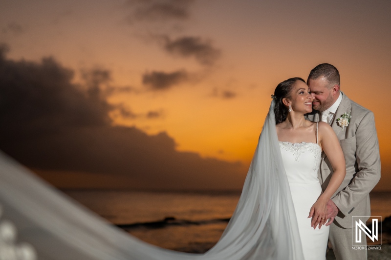 Romantic wedding couple embraces during sunset at Landhuis San Nicolas in Curacao