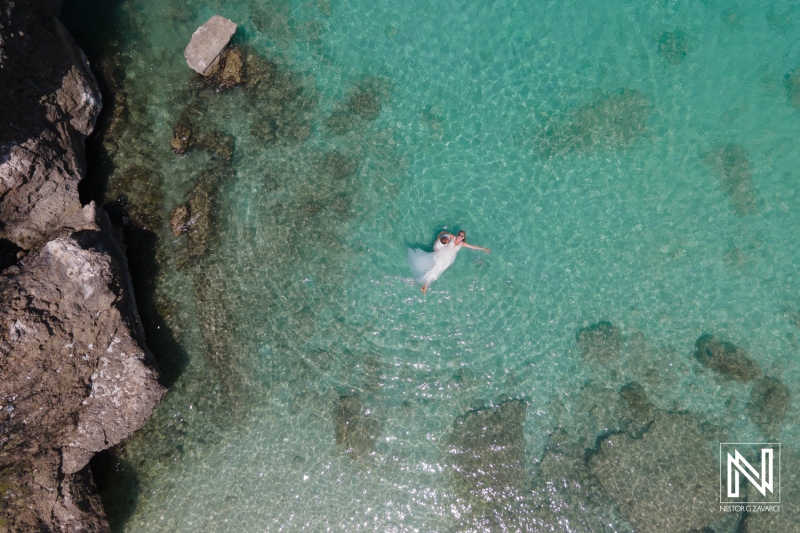 A serene swimmer enjoying the clear turquoise waters near rocky coastline on a sunny day in a tropical paradise