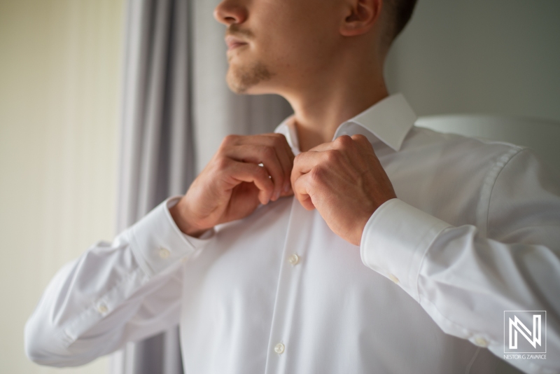 Groom getting into attire
