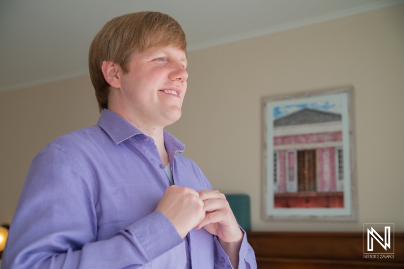 Groom getting into attire
