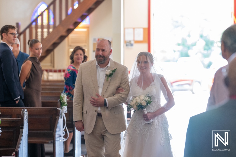 Ceremony in Curacao for Misa Di Jandoret featuring bride and father walking down the aisle during a wedding celebration