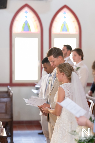 Wedding ceremony at Misa Di Jandoret in Curacao featuring a couple exchanging vows and surrounded by family and friends