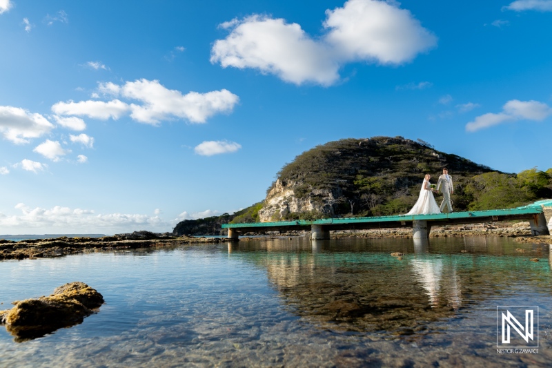 Wedding celebration at a scenic waterfront location in Sint Michiel, Curacao under a bright blue sky with stunning reflections on the water