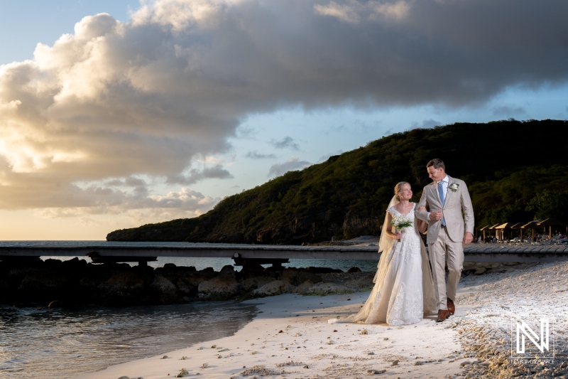 Couple walks hand in hand on the beach at Playa Porto Mari in Curacao during their wedding ceremony at sunset
