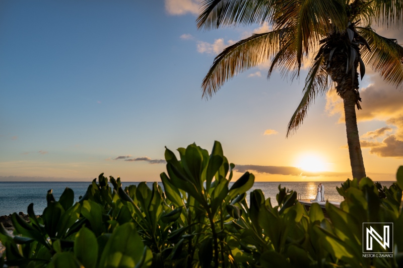 Wedding celebration at sunset on Playa Porto Mari in Curacao with palm trees and ocean view creating a romantic atmosphere
