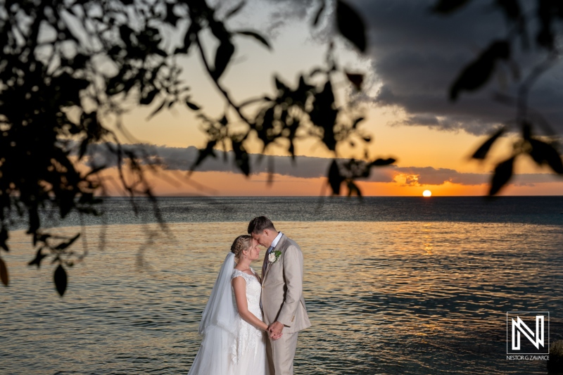 Couple shares a romantic moment during their wedding ceremony at Playa Porto Mari in Curacao at sunset