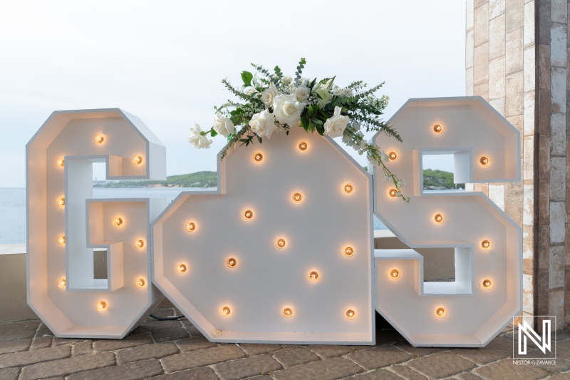 Large light-up letters in a wedding setup at Dreams Curacao Resort with flowers in the background