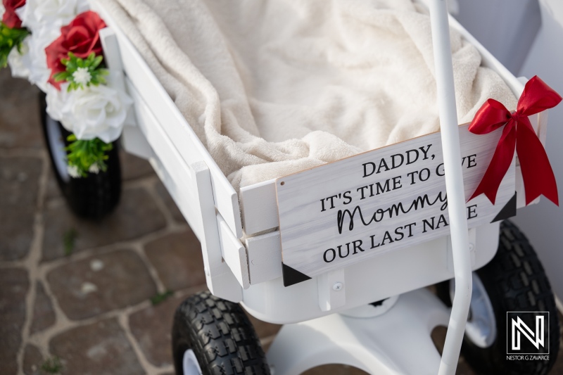 Sign on a wagon at a wedding in Dreams Curacao Resort with a message for parents about a last name
