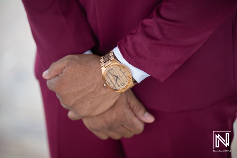 Groom stands with hands clasped at wedding ceremony in Dreams Curacao Resort during sunset with ocean view
