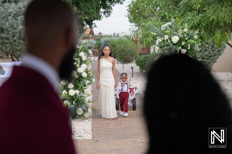 Wedding ceremony in Dreams Curacao Resort with flower girl and ring bearer walking down the aisle outside