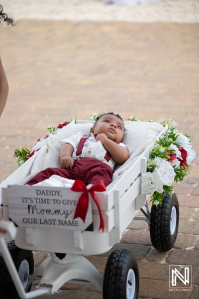 Baby rides in decorated wagon at wedding ceremony in Dreams Curacao Resort on a sunny day