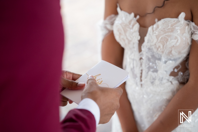 Couple exchanges vows during wedding ceremony at Dreams Curacao Resort on a sunny day by the beach