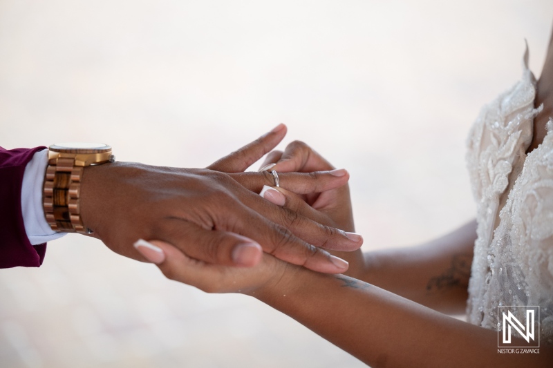 Couples exchange wedding rings at Dreams Curacao Resort during sunset ceremony by the beach