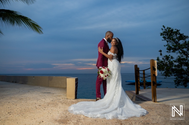 Couple shares a moment during their wedding at Dreams Curacao Resort by the ocean at sunset