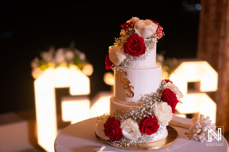 Wedding cake display at Dreams Curacao Resort during a beautiful celebration surrounded by flowers and lights in the evening