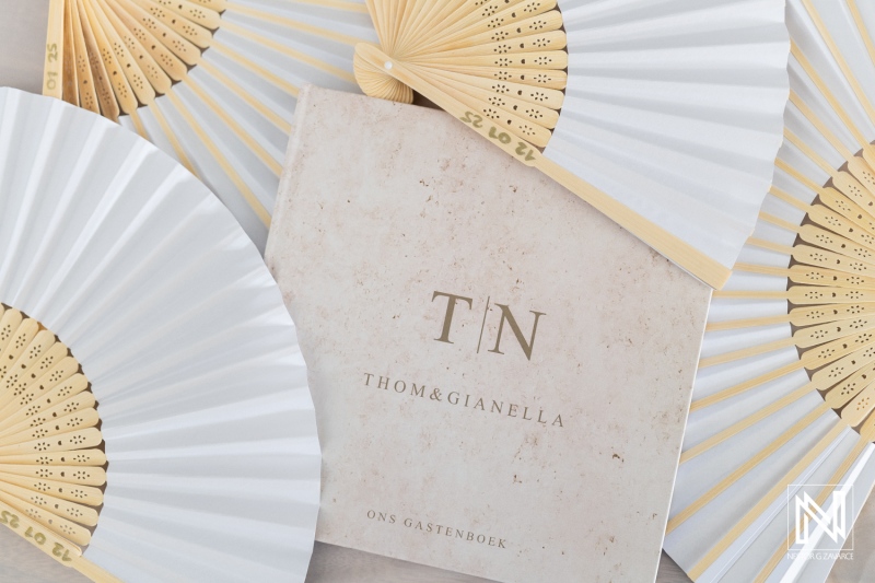Elegant fans and guest book showcasing the charm of a wedding celebration in Curacao, highlighting love and unity in a beautiful setting