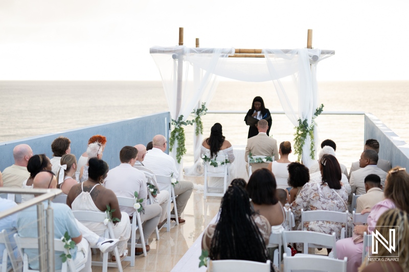Beautiful wedding ceremony in Curacao overlooking the serene sea with an intimate gathering of family and friends