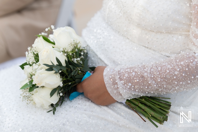 Couple celebrating their wedding in Curacao with a beautiful bouquet of white roses under bright skies