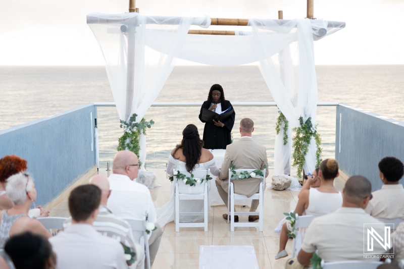 Ceremony on a stunning Curacao terrace as a couple exchanges vows overlooking the ocean during their wedding celebration surrounded by family and friends