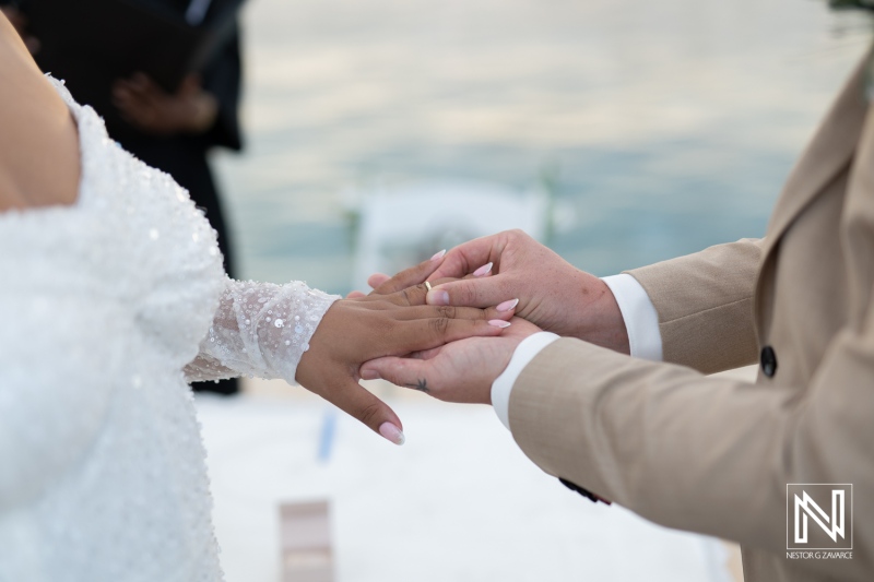 Wedding ceremony taking place on the beautiful shores of Curacao with a couple exchanging vows and rings under the soft sunlight