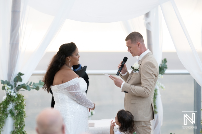 Couple exchanges vows during a romantic wedding ceremony in Curacao overlooking the beautiful ocean sunset