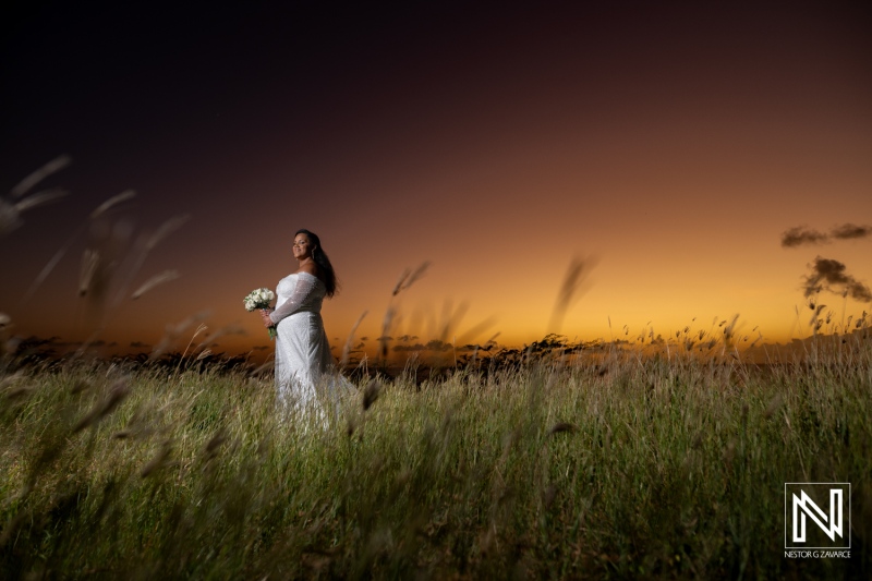 Beautiful wedding celebration in Curacao at sunset with a bride holding a bouquet in a grassy field