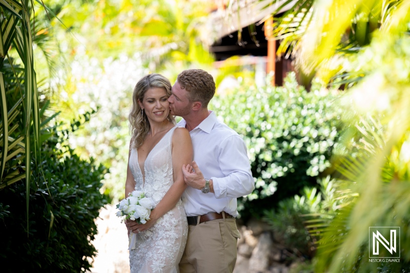 Couple enjoys a special moment together at their wedding in Mood Beach, Curacao, surrounded by lush greenery and natural beauty