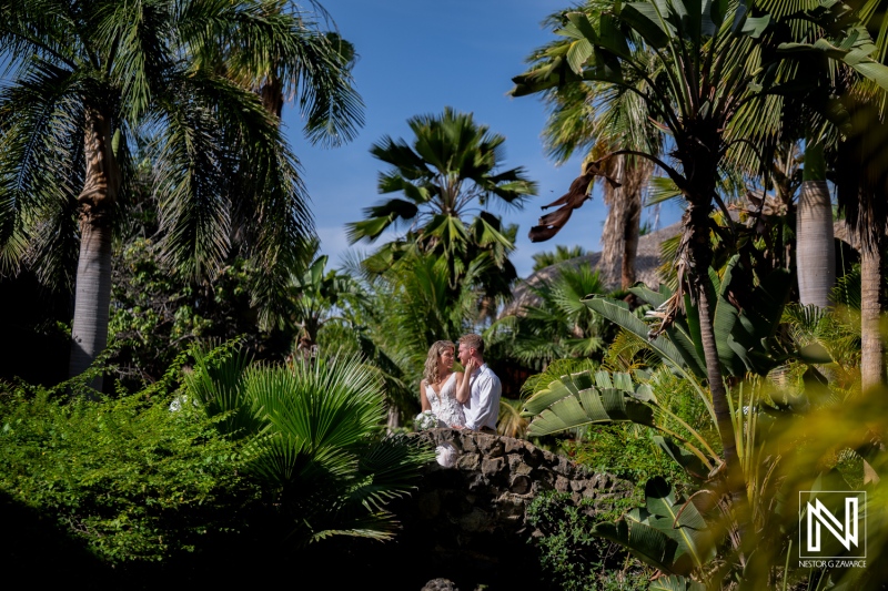 Wedding celebration at Mood Beach in Curacao with couple amidst tropical plants and blue sky