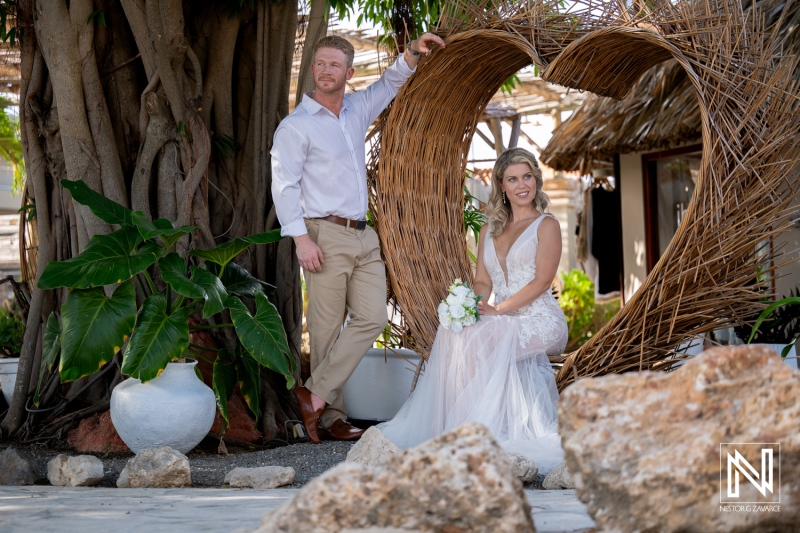 Wedding celebration at Mood Beach in Curacao with couple sitting by natural decor