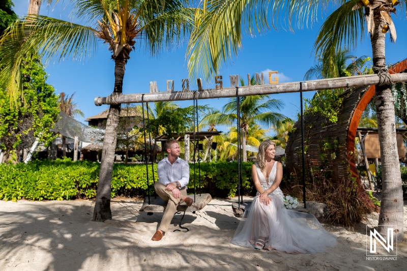 Couple celebrates wedding on Mood Beach in Curacao with swing and palm trees