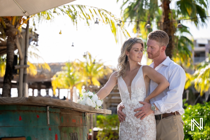 Couple shares moment during wedding at Mood Beach in Curacao surrounded by palm trees and a beautiful setting