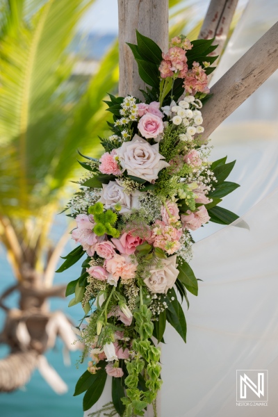 Wedding decorations at Mood Beach in Curacao show floral arrangements with greenery on a sunny day
