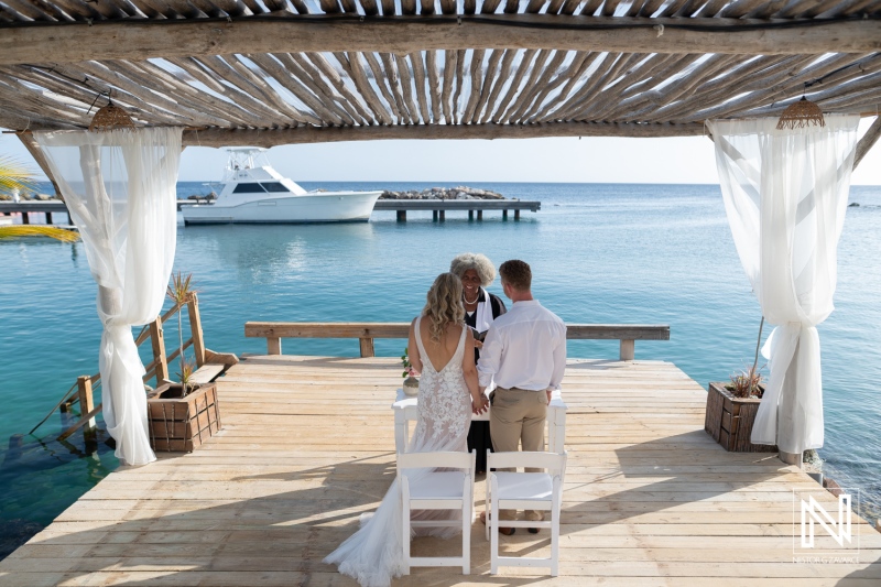 Wedding ceremony at Mood Beach in Curacao near the water with a boat in view on a sunny day