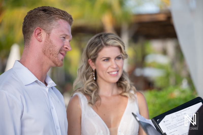Couple exchanges vows during their wedding ceremony at Mood Beach in Curacao in the warm afternoon sun