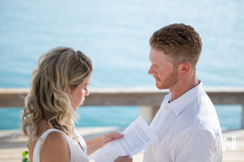 Couple exchanges vows during wedding ceremony at Mood Beach in Curacao under clear sky and bright sun