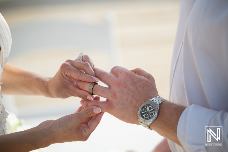 Wedding ceremony at Mood Beach in Curacao with ring exchange during the vows at a sunny moment