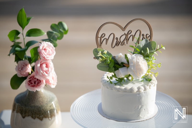 Couple celebrates their wedding at Mood Beach in Curacao with cake and floral decorations