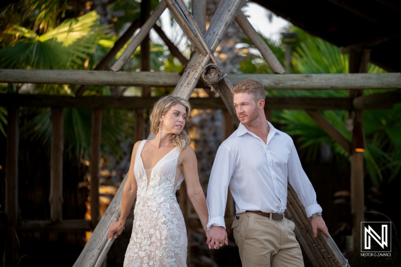 Couple holding hands at a wedding ceremony on Mood Beach in Curacao during sunset