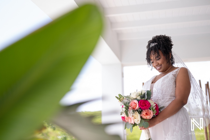 A Bride in a Stunning White Dress Holds a Vibrant Bouquet While Standing in a Beautifully Decorated Venue During a Sunny Outdoor Wedding Ceremony