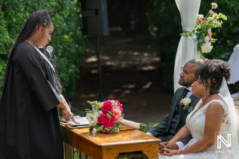 A Wedding Ceremony in a Lush Garden Featuring an Officiant Speaking to a Couple Who Are Exchanging Vows Amidst Beautiful Floral Arrangements