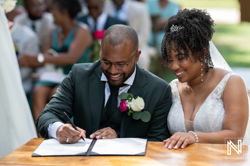 A Joyful Couple Signs Their Marriage Certificate Outdoors During a Beautiful Wedding Ceremony Surrounded by Family and Friends on a Sunny Day