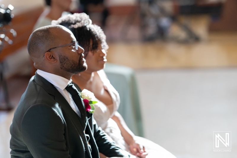 A Couple Sits Together During Their Wedding Ceremony in a Beautifully Lit Venue, Surrounded by Family and Friends, Celebrating Their Love and Commitment in an Intimate Moment