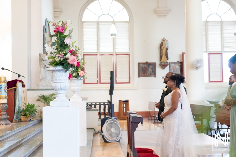 A Couple Stands at the Altar in a Beautifully Decorated Church During Their Wedding Ceremony, Featuring Floral Arrangements and a Serene Ambiance in the Background