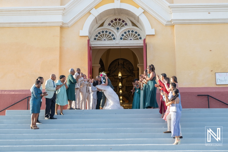 A Joyful Wedding Celebration at a Historic Church Entrance Featuring a Bride and Groom Embracing Their Guests With Love and Laughter in a Warm Afternoon Setting