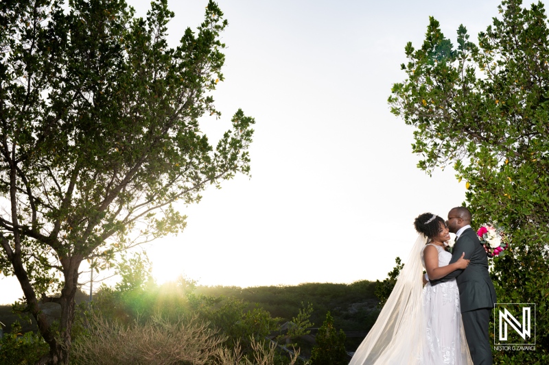 Couple Sharing a Romantic Kiss at Sunset Surrounded by Nature During Their Wedding Ceremony in an Outdoor Venue