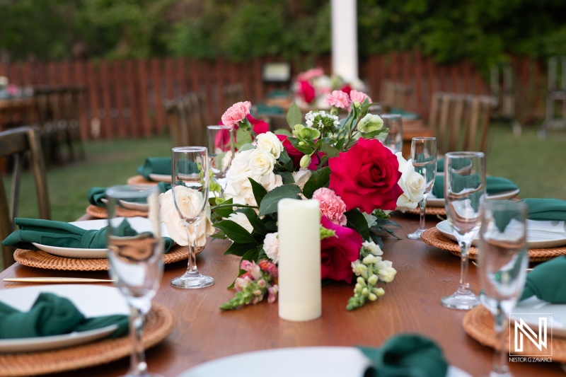 Elegant Outdoor Dining Setup Featuring a Beautiful Floral Centerpiece, Table Settings, and Soft Lighting for an Event in a Garden During the Evening