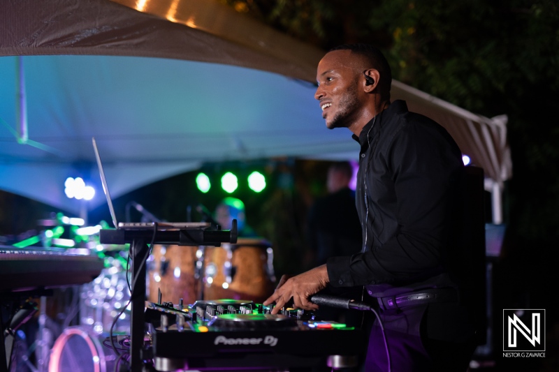 A Skilled DJ Mixes Vibrant Beats at an Outdoor Evening Event Under a Tent With Lively Lighting and Audience Ambiance